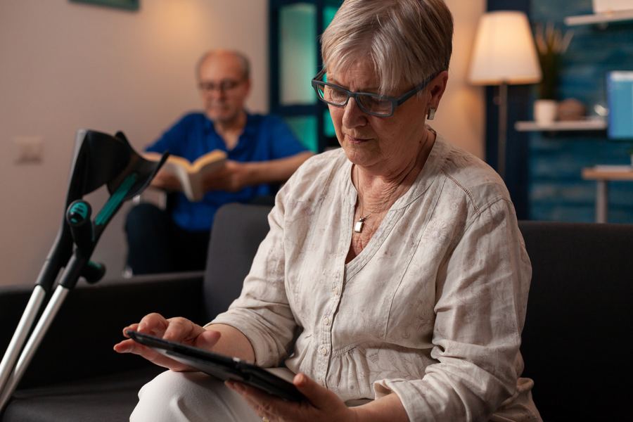 An older adult using a tablet at home.
